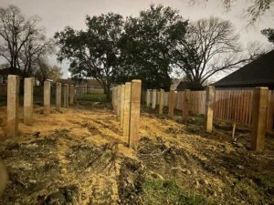 Wooden posts set in muddy construction site